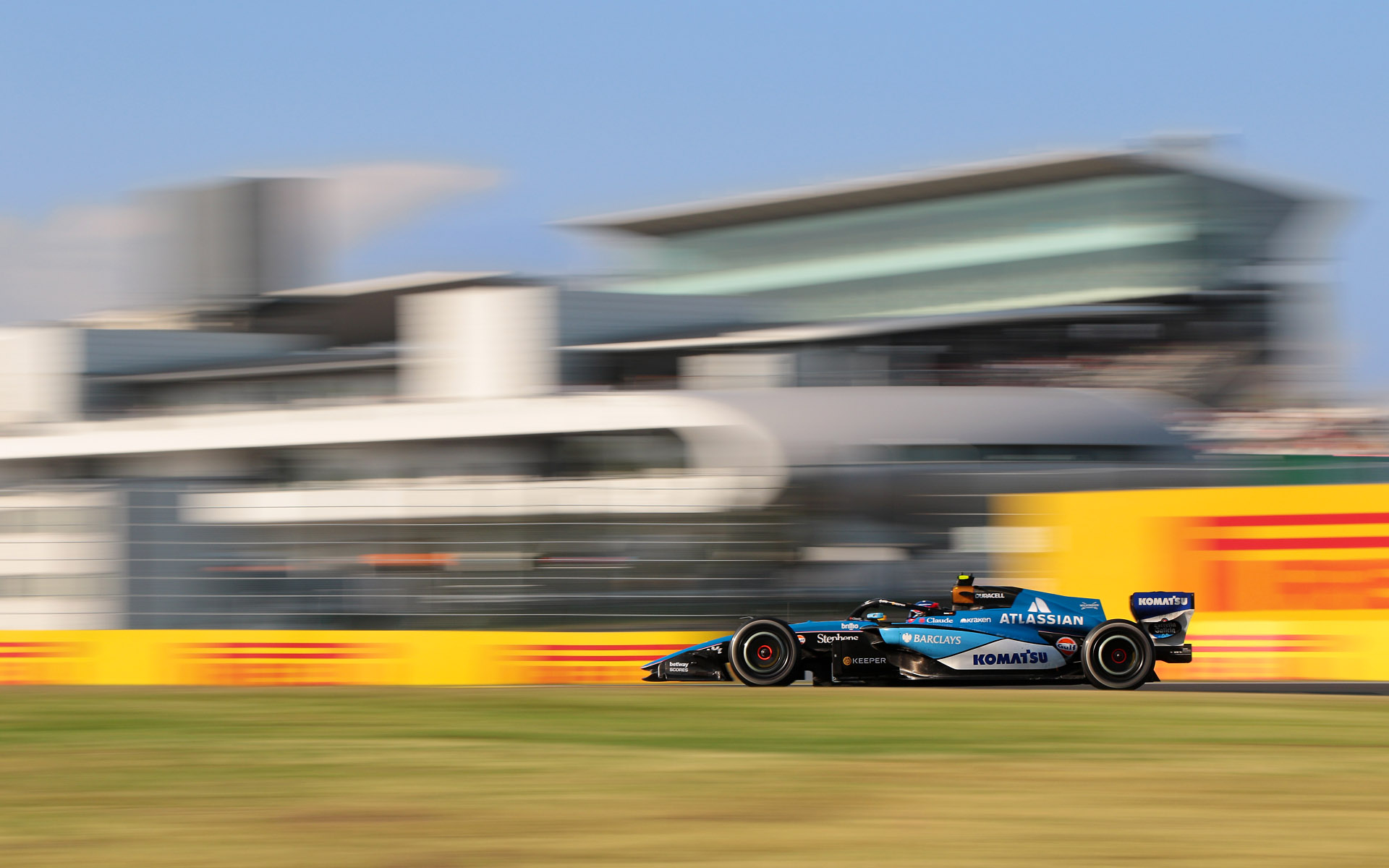 背景にピットビル、グランドスタンドを入れて焦点距離73mm、シャッター速度1/60秒で撮影