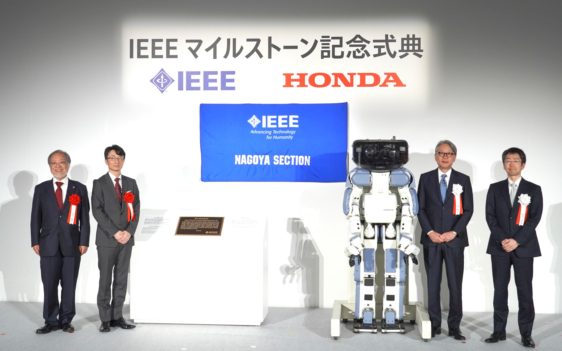 銘板とP2を囲んで記念撮影。左から名古屋大学名誉教授 福田敏男氏、IEEE名古屋支部長 上原秀幸氏、本田技研工業株式会社取締役代表執行役社長 三部敏宏氏、株式会社本田技術研究所 代表取締役社長 秋和利祐氏