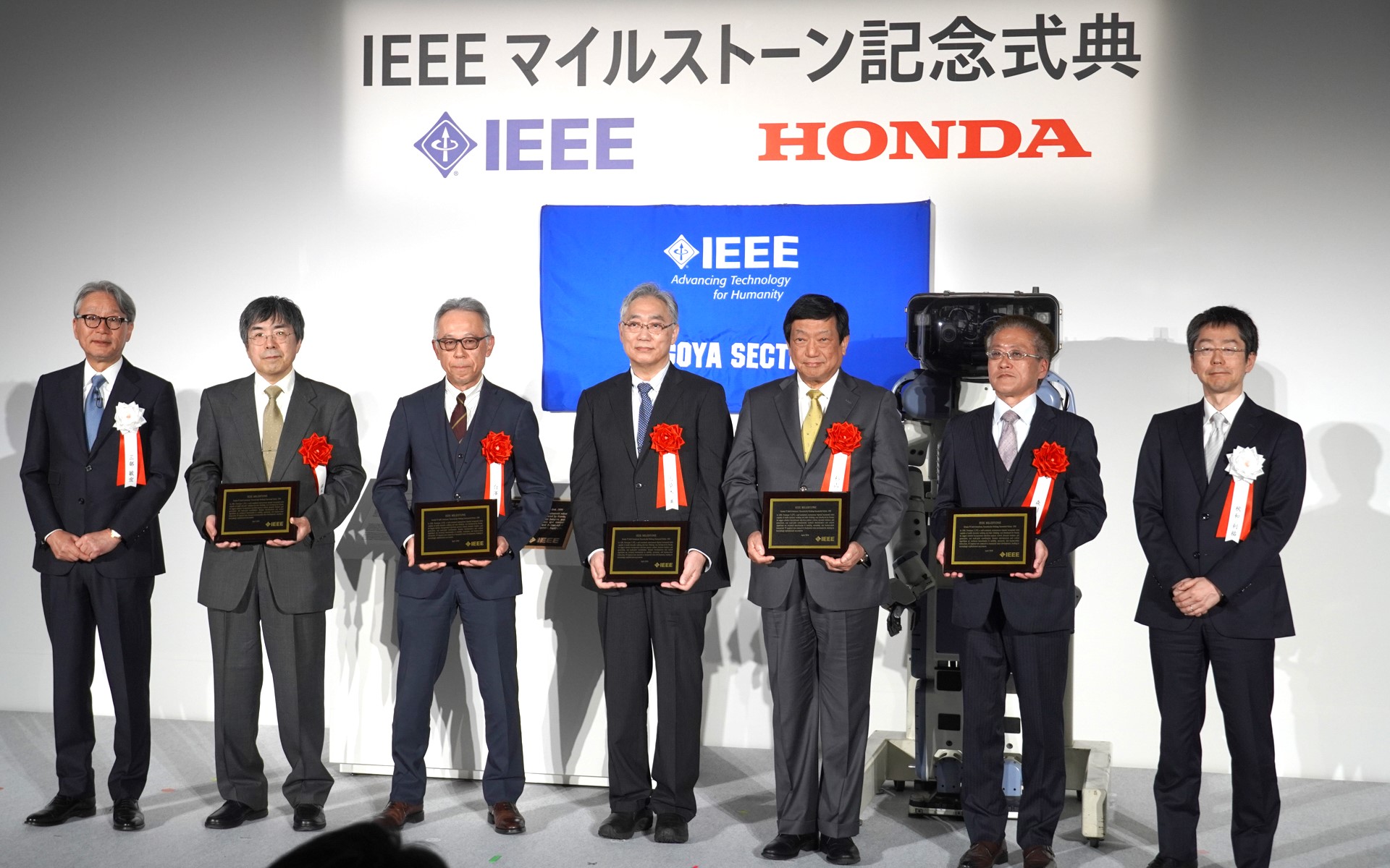 当時の開発パートナーへ感謝プレートを贈呈して記念撮影