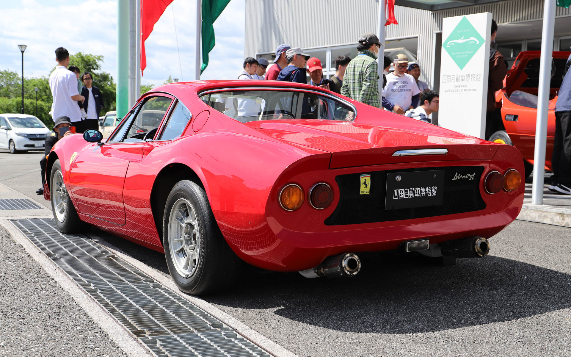 「ディーノ 246GT」。フェラーリを名乗ることができなかった、あるいは、わざと名乗らなかったなど、さまざまな説があるモデル（四国自動車博物館の所蔵車両はフェラーリのシールを貼っている）。エンツォ・フェラーリ氏の息子で、V型6気筒エンジンの開発に携わっていたアルフレード氏の愛称となる「ディーノ」からモデル名が付けられている。V型6気筒2.4リッターエンジンをミッドシップに搭載。デザインはイタリアの名門カロッツェリアのピニンファリーナが担当した。なお、展示車両はルーフ、ボディ外板、車内まで破損した車両をレストアしており、シートやダッシュボードなどはレース仕様に仕上げられ、フロントノーズ、左右ドア、トランクリッド部分にアルミを採用したことで約200kg軽量化するとともに、車高も30mmダウンしている。オーナーはダウンヒルの大会に出場したり、高知-東京間を往復したり、「ディーノ 246GT」を溺愛していたとのこと