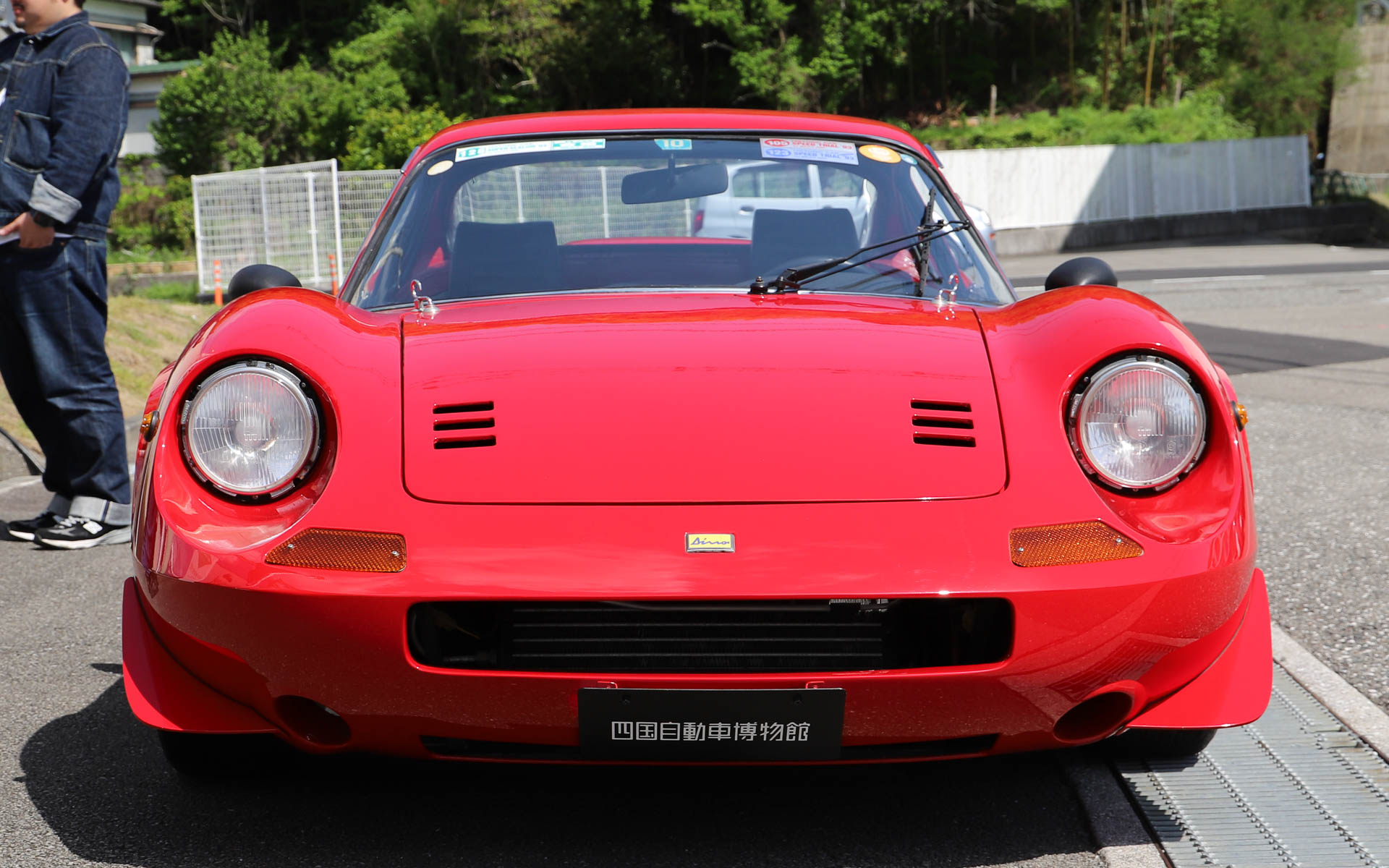 「ディーノ 246GT」。フェラーリを名乗ることができなかった、あるいは、わざと名乗らなかったなど、さまざまな説があるモデル（四国自動車博物館の所蔵車両はフェラーリのシールを貼っている）。エンツォ・フェラーリ氏の息子で、V型6気筒エンジンの開発に携わっていたアルフレード氏の愛称となる「ディーノ」からモデル名が付けられている。V型6気筒2.4リッターエンジンをミッドシップに搭載。デザインはイタリアの名門カロッツェリアのピニンファリーナが担当した。なお、展示車両はルーフ、ボディ外板、車内まで破損した車両をレストアしており、シートやダッシュボードなどはレース仕様に仕上げられ、フロントノーズ、左右ドア、トランクリッド部分にアルミを採用したことで約200kg軽量化するとともに、車高も30mmダウンしている。オーナーはダウンヒルの大会に出場したり、高知-東京間を往復したり、「ディーノ 246GT」を溺愛していたとのこと