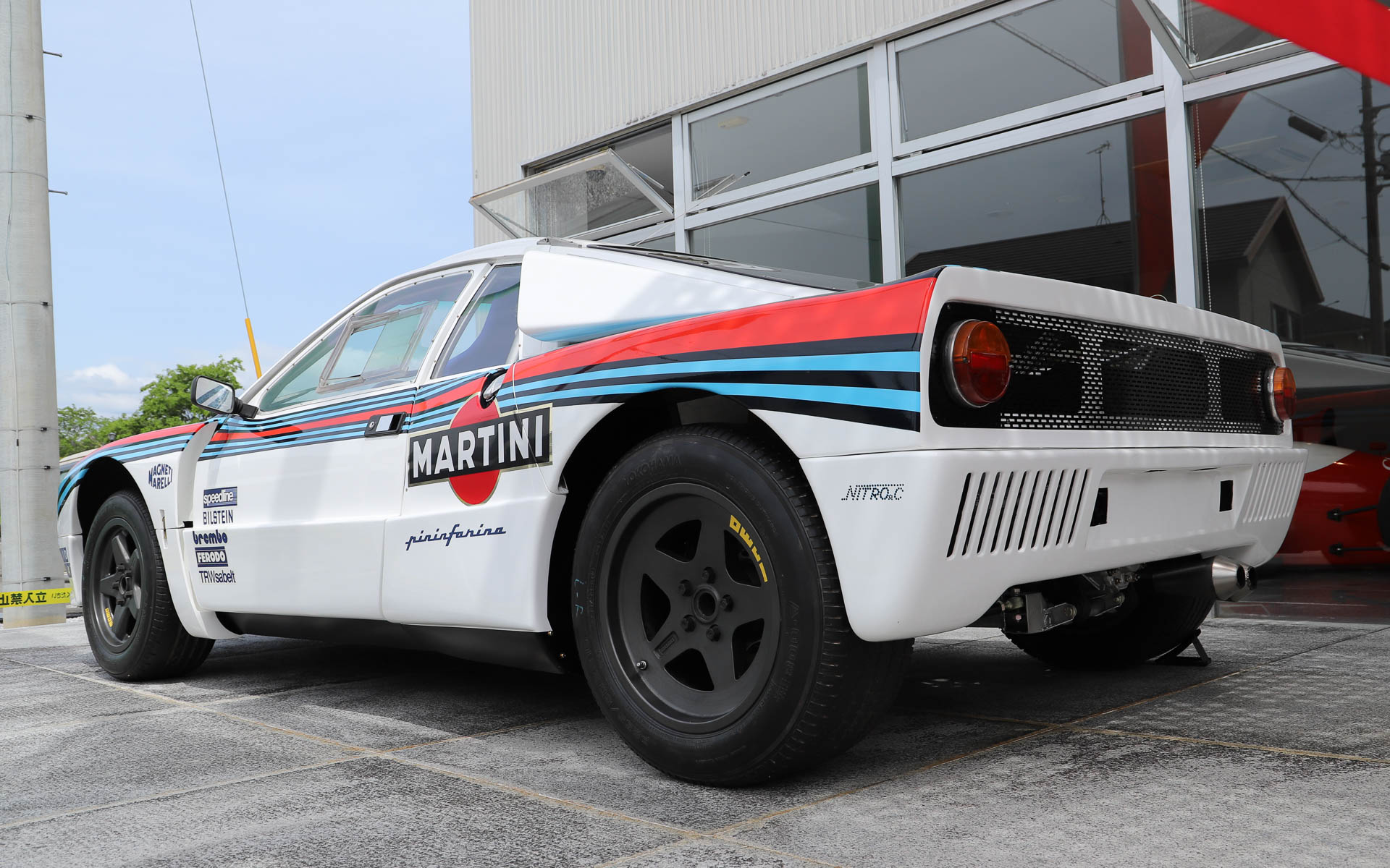 「ランチア・ラリー037」。4WDが台頭してきた1980年代のWRCに、あえてミッドシップで挑んだ車両。過酷なレースのため、現存するワークスマシンは約半数と言われている。デザインはピニンファリーナが担当した。ボディはケブラーとカーボンファイバーで構成され、当時としてはかなり軽量とされている。整備性を高めるため、エンジンルームへのアクセスがしやすいような工夫がされており、ボンネットはパイプ1本で支えるだけとなっている。エンジンは「アバルト・131」の直列4気筒エンジンをベースにチューニングし、スーパーチャージャーを搭載することで、低回転域からパワーを発揮する