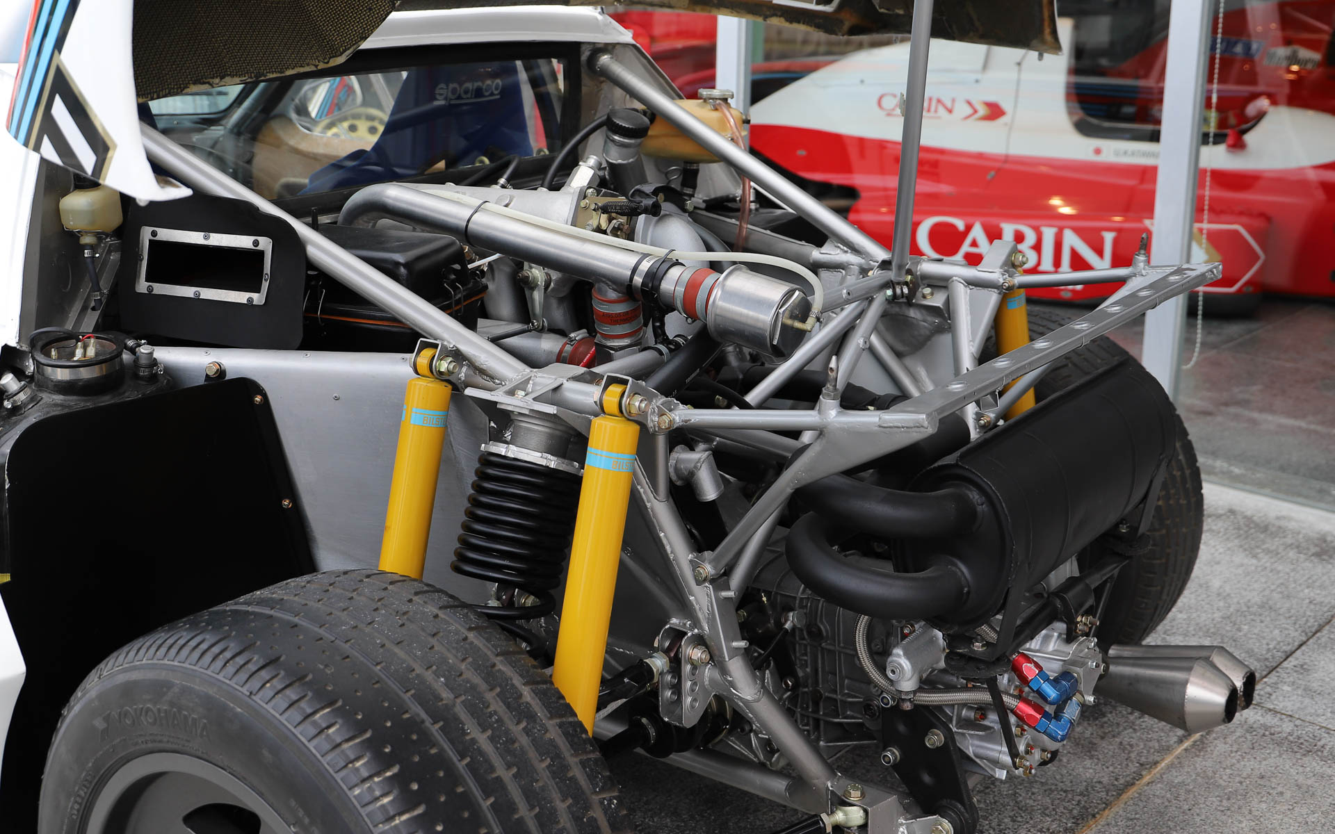 「ランチア・ラリー037」。4WDが台頭してきた1980年代のWRCに、あえてミッドシップで挑んだ車両。過酷なレースのため、現存するワークスマシンは約半数と言われている。デザインはピニンファリーナが担当した。ボディはケブラーとカーボンファイバーで構成され、当時としてはかなり軽量とされている。整備性を高めるため、エンジンルームへのアクセスがしやすいような工夫がされており、ボンネットはパイプ1本で支えるだけとなっている。エンジンは「アバルト・131」の直列4気筒エンジンをベースにチューニングし、スーパーチャージャーを搭載することで、低回転域からパワーを発揮する