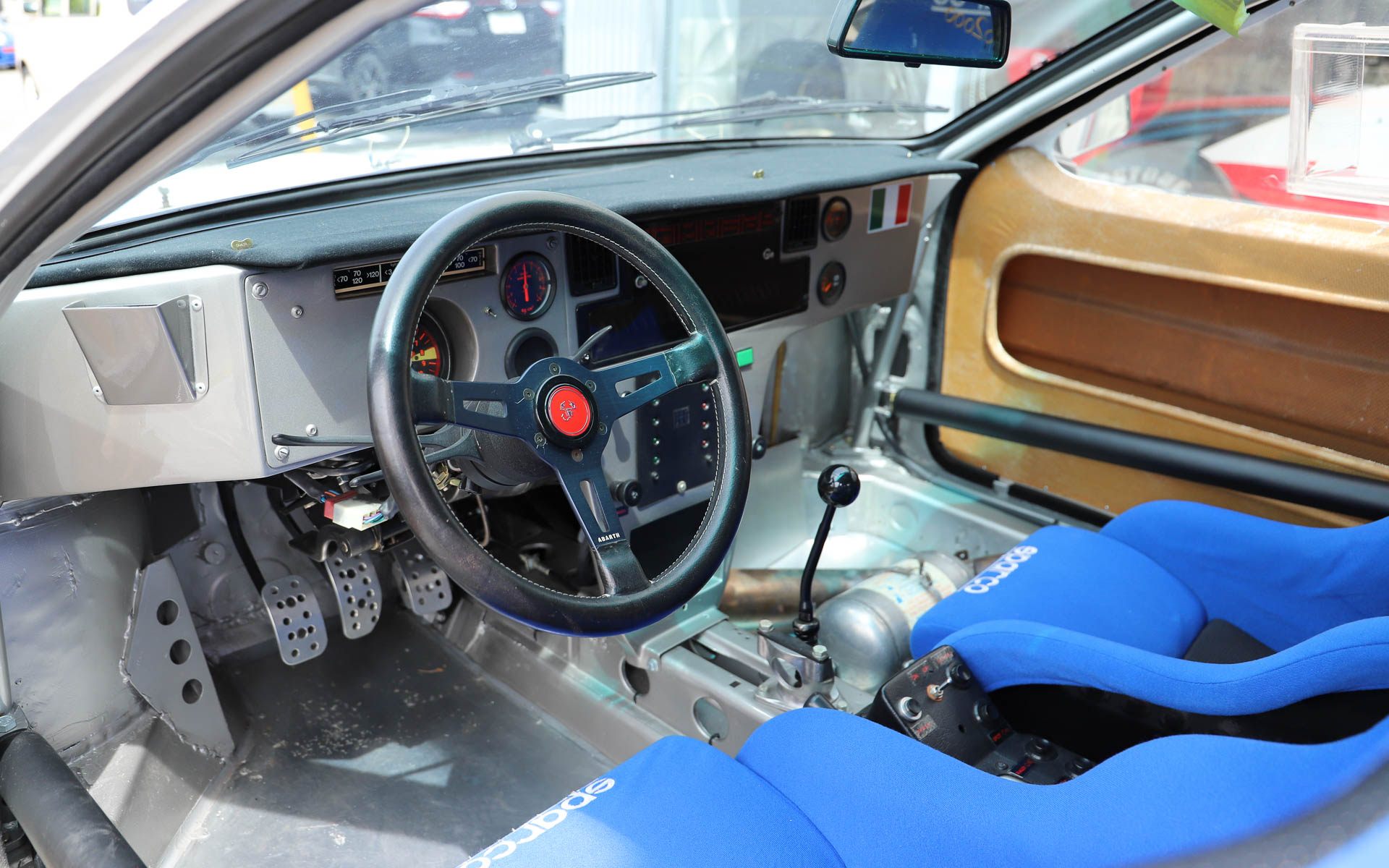 「ランチア・ラリー037」。4WDが台頭してきた1980年代のWRCに、あえてミッドシップで挑んだ車両。過酷なレースのため、現存するワークスマシンは約半数と言われている。デザインはピニンファリーナが担当した。ボディはケブラーとカーボンファイバーで構成され、当時としてはかなり軽量とされている。整備性を高めるため、エンジンルームへのアクセスがしやすいような工夫がされており、ボンネットはパイプ1本で支えるだけとなっている。エンジンは「アバルト・131」の直列4気筒エンジンをベースにチューニングし、スーパーチャージャーを搭載することで、低回転域からパワーを発揮する
