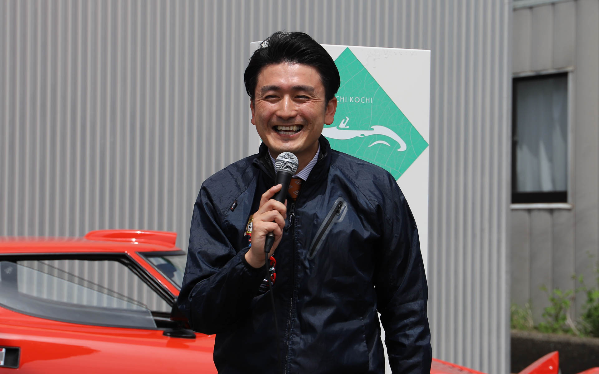 ネッツトヨタ南国株式会社 常務取締役 横田忠明氏。横田氏いわく、四国自動車博物館はネッツトヨタ南国が「手弁当で運営している施設」とのことで、開催のあいさつでは「四国自動車博物館がクルマ好きの方が高知に来ていただける目的地になれば」と話していた