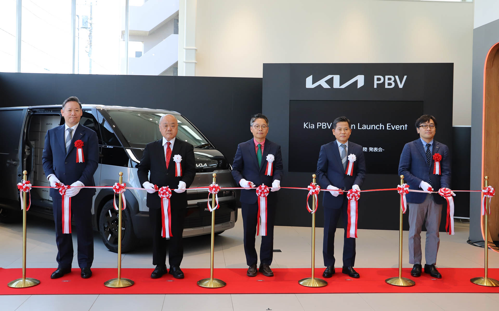 Kia PBV 東京西のオープンを記念してテープカットが行なわれた。左からKia PBVジャパン株式会社 代表取締役 CEO 田島靖也氏、自動車輸入組合（JAIA）副理事長兼専務理事 入野泰一氏、日本国大韓民国大使館 公使参事官 商務官 ジョン・ギョンロク氏、Kia Corporation PBVビジネス事業部 副社長 キム・サンデ氏、双日株式会社 自動車本部 自動車第二部 部長 畠山忠重氏