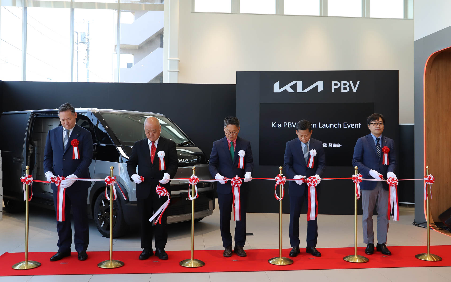 Kia PBV 東京西のオープンを記念してテープカットが行なわれた。左からKia PBVジャパン株式会社 代表取締役 CEO 田島靖也氏、自動車輸入組合（JAIA）副理事長兼専務理事 入野泰一氏、日本国大韓民国大使館 公使参事官 商務官 ジョン・ギョンロク氏、Kia Corporation PBVビジネス事業部 副社長 キム・サンデ氏、双日株式会社 自動車本部 自動車第二部 部長 畠山忠重氏