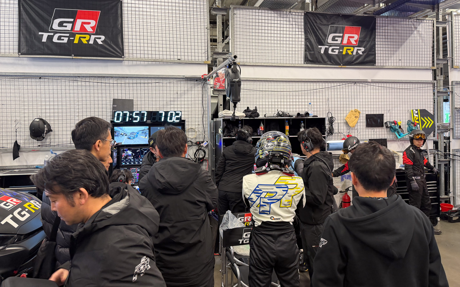 チームスタッフに109号車 GRヤリスのチェック状況を報告する大嶋和也選手。ピットには、チームを見守る成瀬弘氏の遺影がある