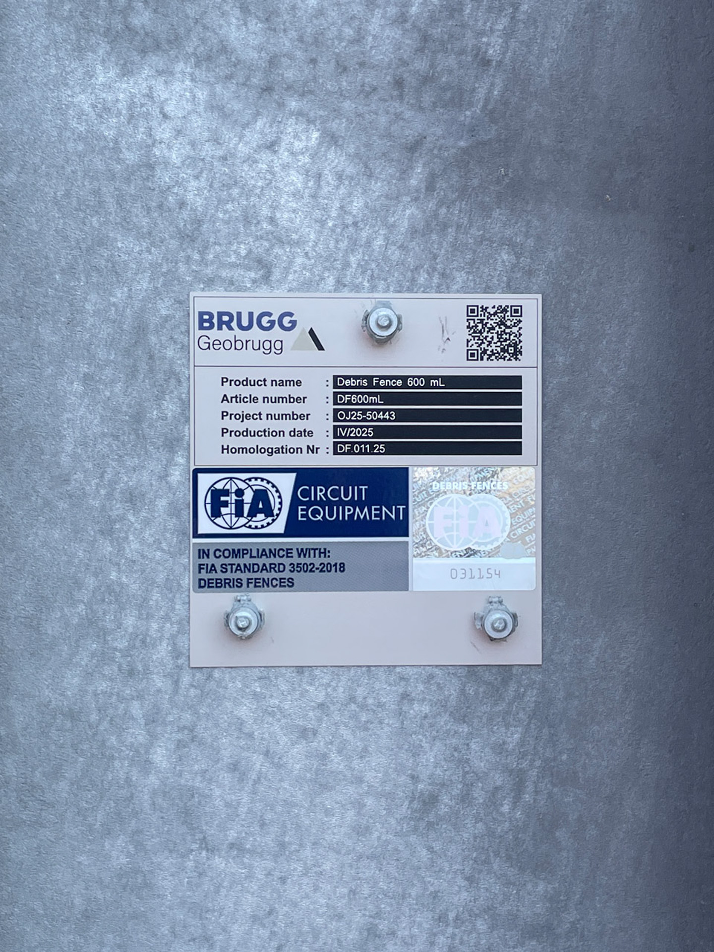 フェンスに貼られたFIA公認のシール。QRコードのリンク先はBRUGG GEOBRUGG社のウェブサイト