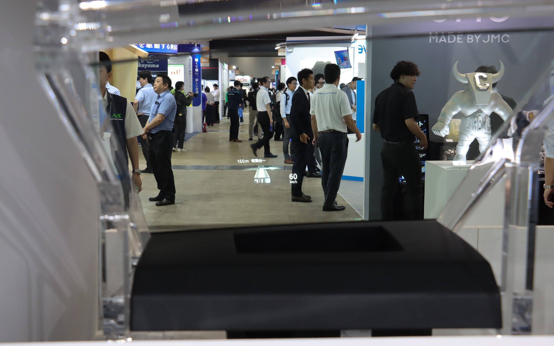 デモ機はブース側から通路に向けて設置され、通路の上にナビのルート案内情報などが表示されていた