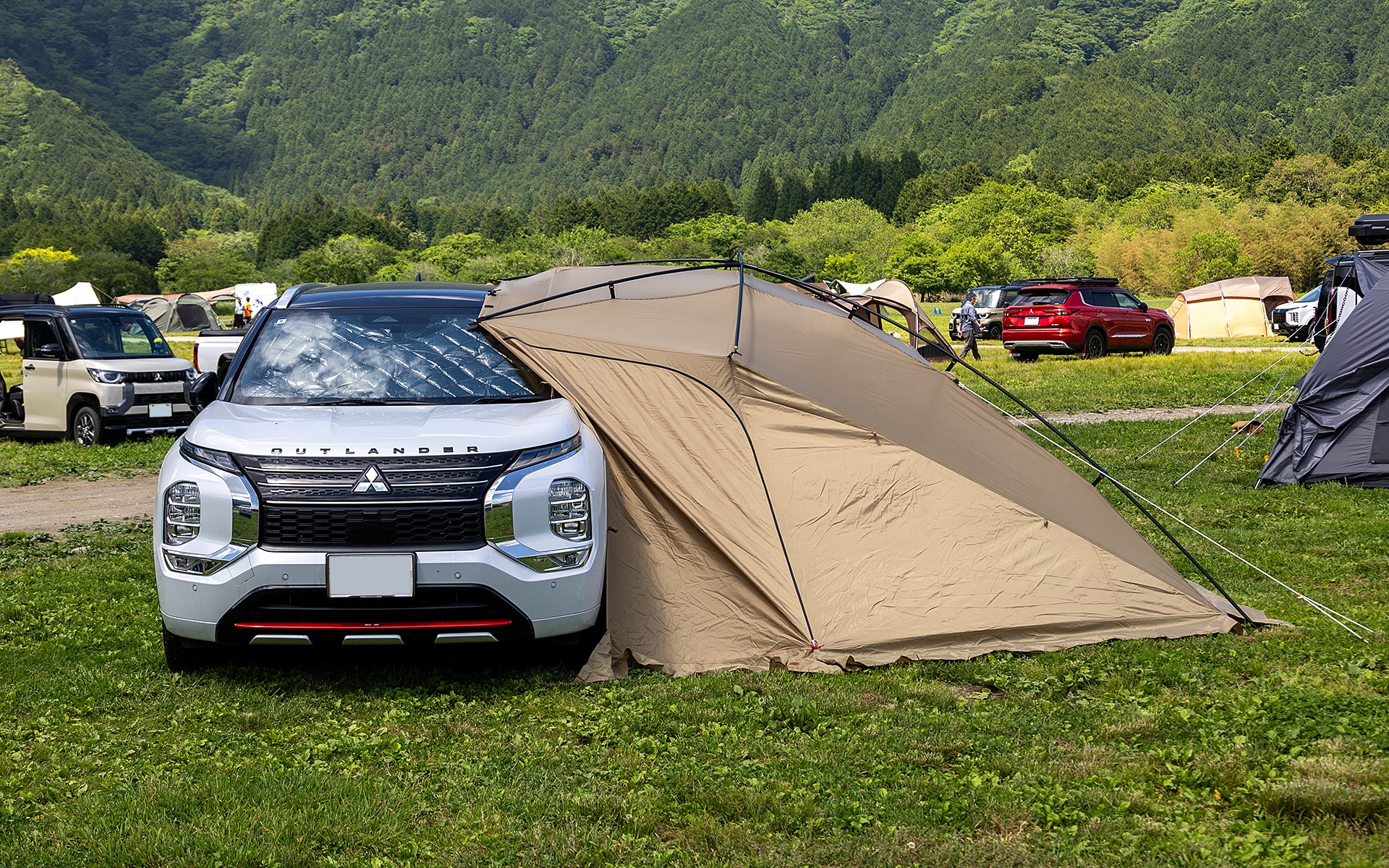移動する蓄電池として、アウトドアで便利なアウトランダーPHEV。カーサイドタープを付けることで電気製品を使うのに適したリビングも作れる。カーサイドタープはキャンパルジャパン製
