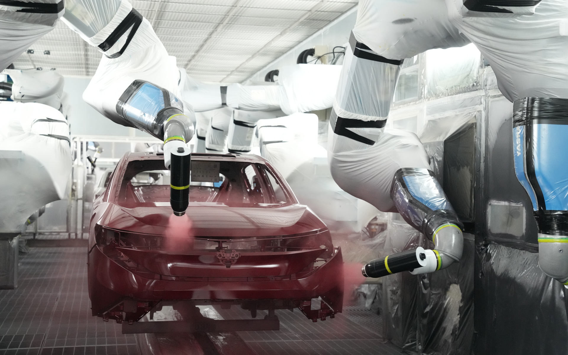 日産自動車の栃木工場における「ドライブース方式」の塗装工程。ロボットアームが車体に塗料を吹き付ける