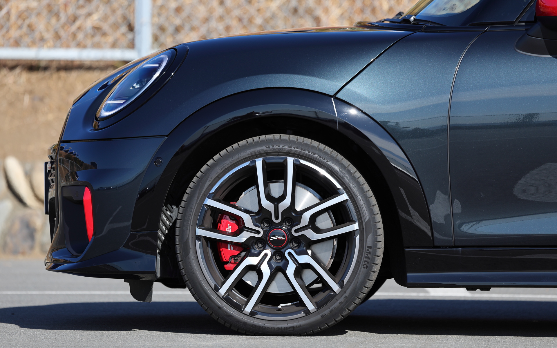 18インチホイールに組み合わせられるのはピレリ「CINTURATO P7」（215/40R18）。JOHN COOPER WORKSのロゴ入りレッドキャリパーもスポーツマインドをくすぐるアイテム