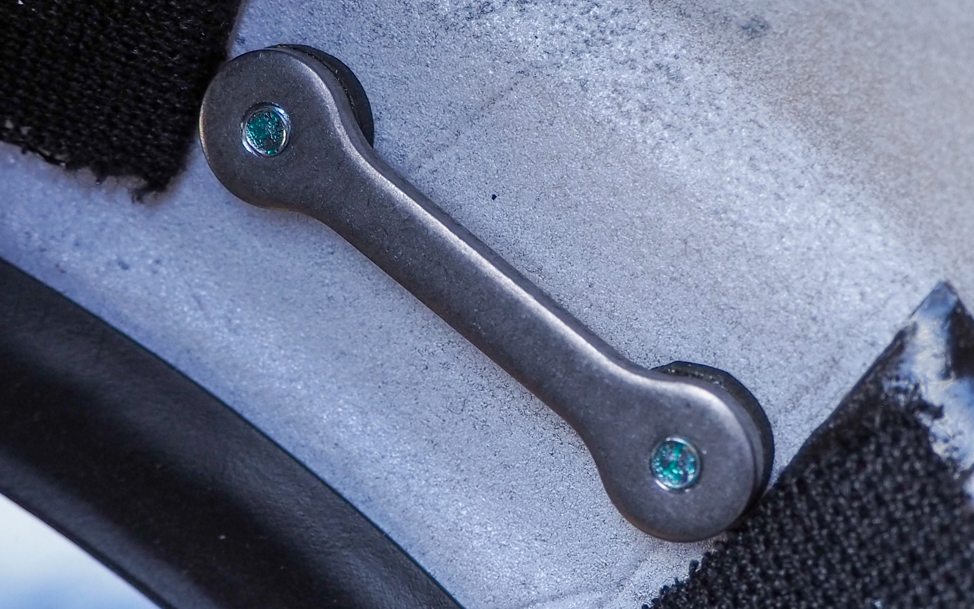 ヘルメット内側にあるセンターロック操作部の固定器具。金属プレートとヘルメットの間にゴム製の緩衝材を挟むことで微振動を吸収しつつ、閉じた際の密閉感や開閉時のスムーズな操作を実現した