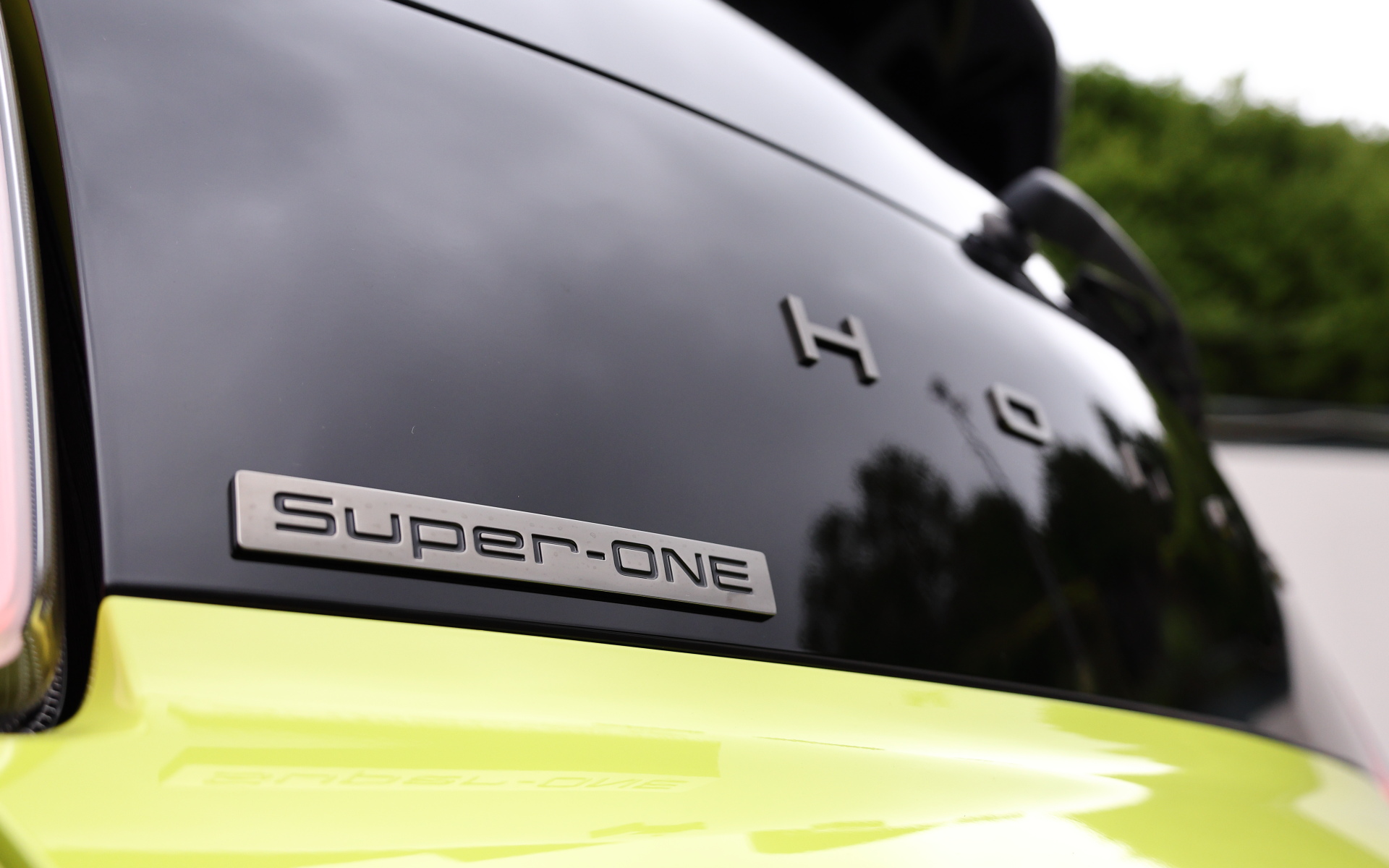 会場には標準車以外にホンダアクセスの純正アクセサリーによるエクステリアコーディネイト「BULLDOG STYLE（ブルドッグ スタイル）」モデルも展示。シティ・ターボIIの書体を再現した「BULLDOG」デカールをはじめ、スポーティな走りを想起させる「テールゲートスポイラー」、発光色のイエローとクリアの切り替えが可能な「LEDフォグライト バイカラー」、ベルリナブラックの「15インチアルミホイールME-027」、スーパーワンの車名プレートも付属する「ブラックエンブレム」を装着。インテリア向けとしてはスポーツペダルやUSB PDチャージャー（Type-C）なども用意される