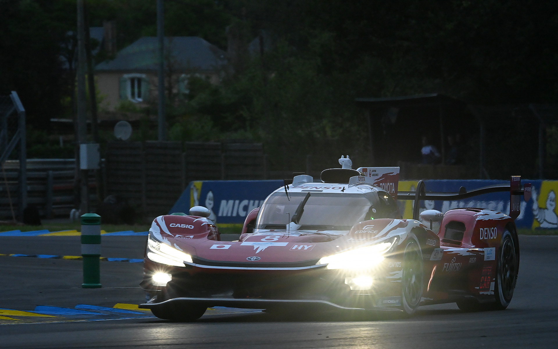 日が沈みつつあるル・マンのサルト・サーキットを走るトヨタレーシング TR010ハイブリッド