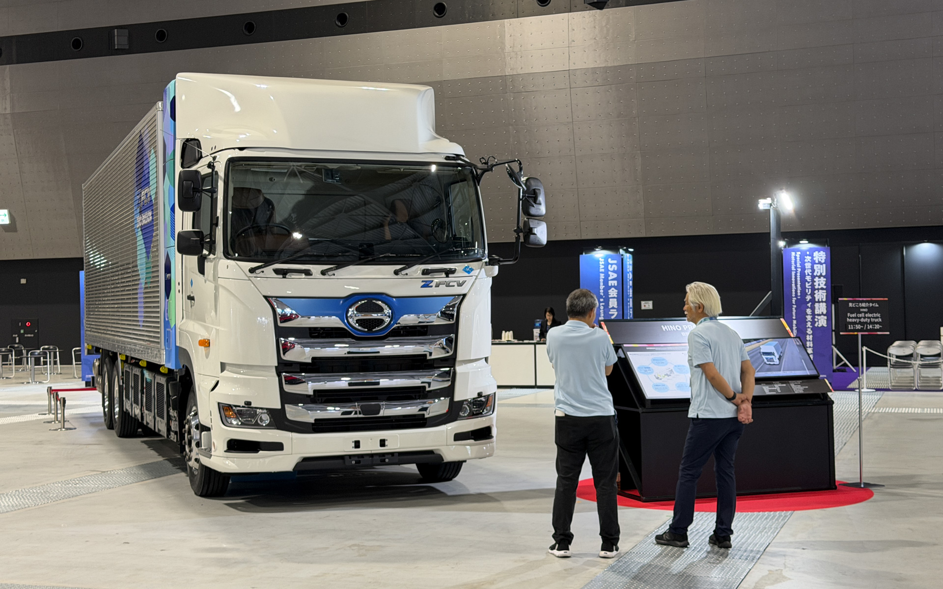 日野自動車の「プロフィア Z FCV」の実車と技術解説パネルの展示。長距離輸送をゼロエミッションで実現する水素充填・航続距離などの特徴を紹介