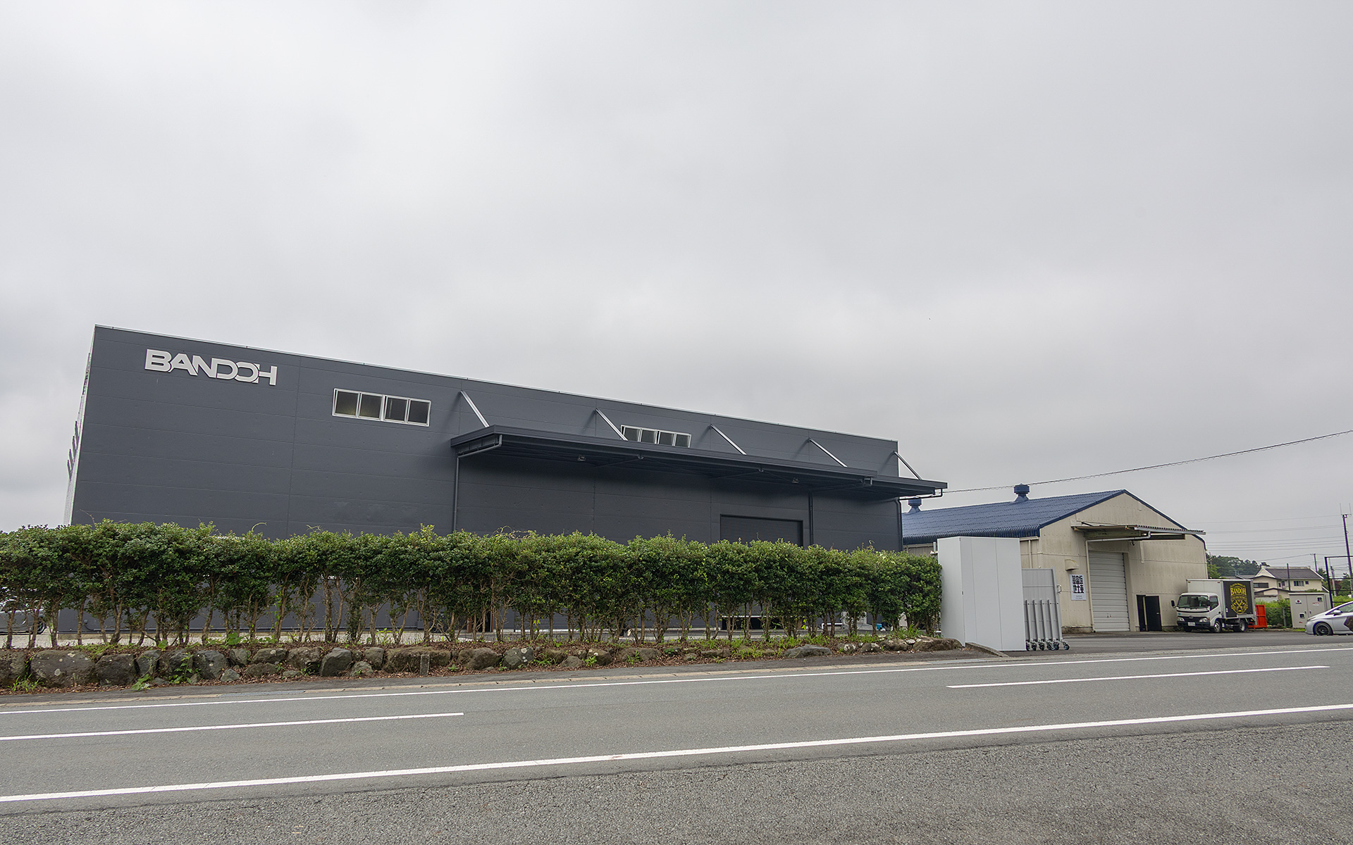 RACING PROJECT BANDOHではレース活動を行なう拠点として、以前から御殿場市内に工場を構えていた。その拠点でも十分な機能を持っていたが、さらなる発展と新たな取り組みを進めるために静岡県御殿場市永塚に新工場「RACING PROJECT BANDOH FUJI BASE FACTORY」を建設した
