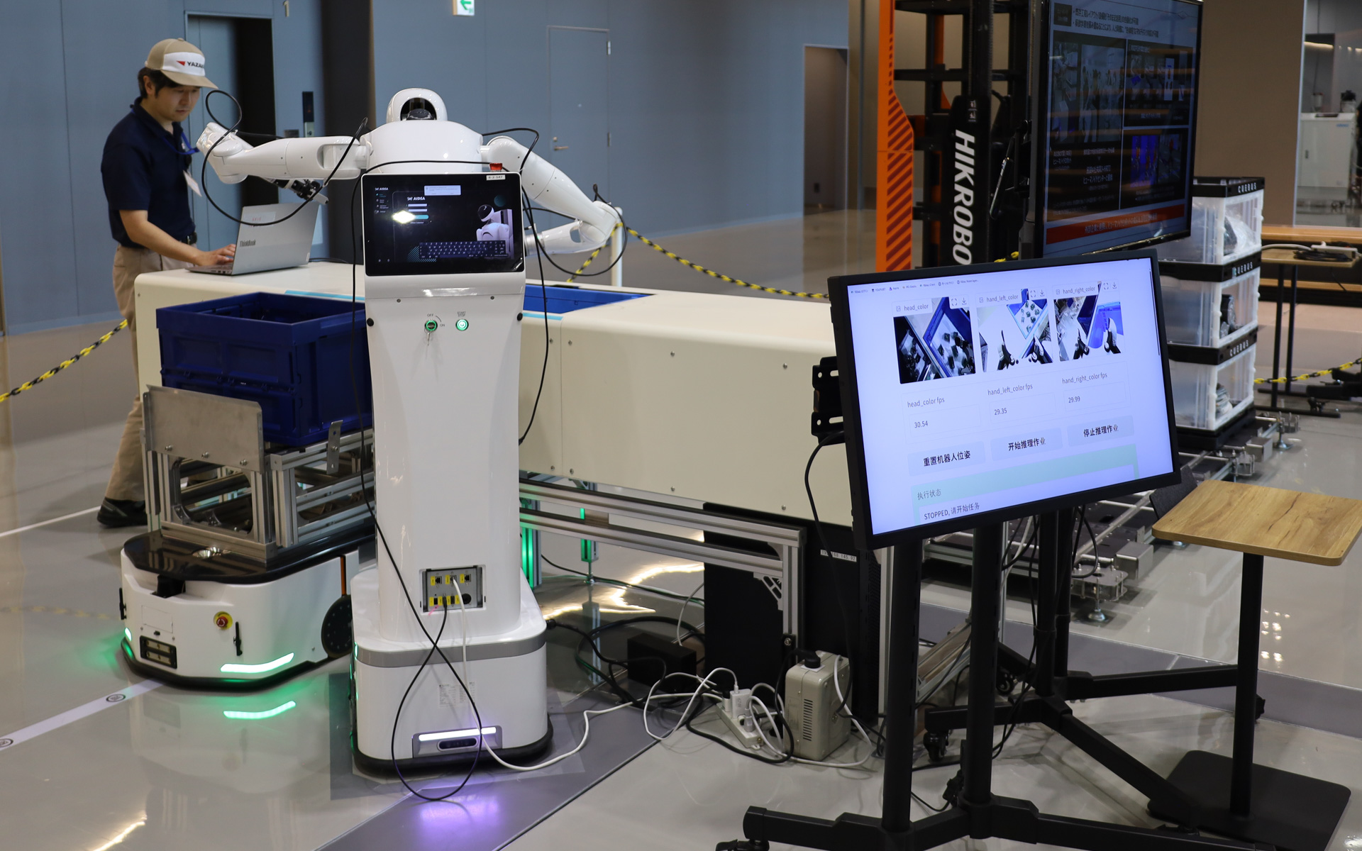 二足歩行型ロボットでなく台車付きの形状が採用されているのは、「ワイヤーハーネスの生産工程は非常にハンドワークがメインなので、ここでは二足歩行するよりもAGV（無人搬送車）のほうがより合理的である」という判断から