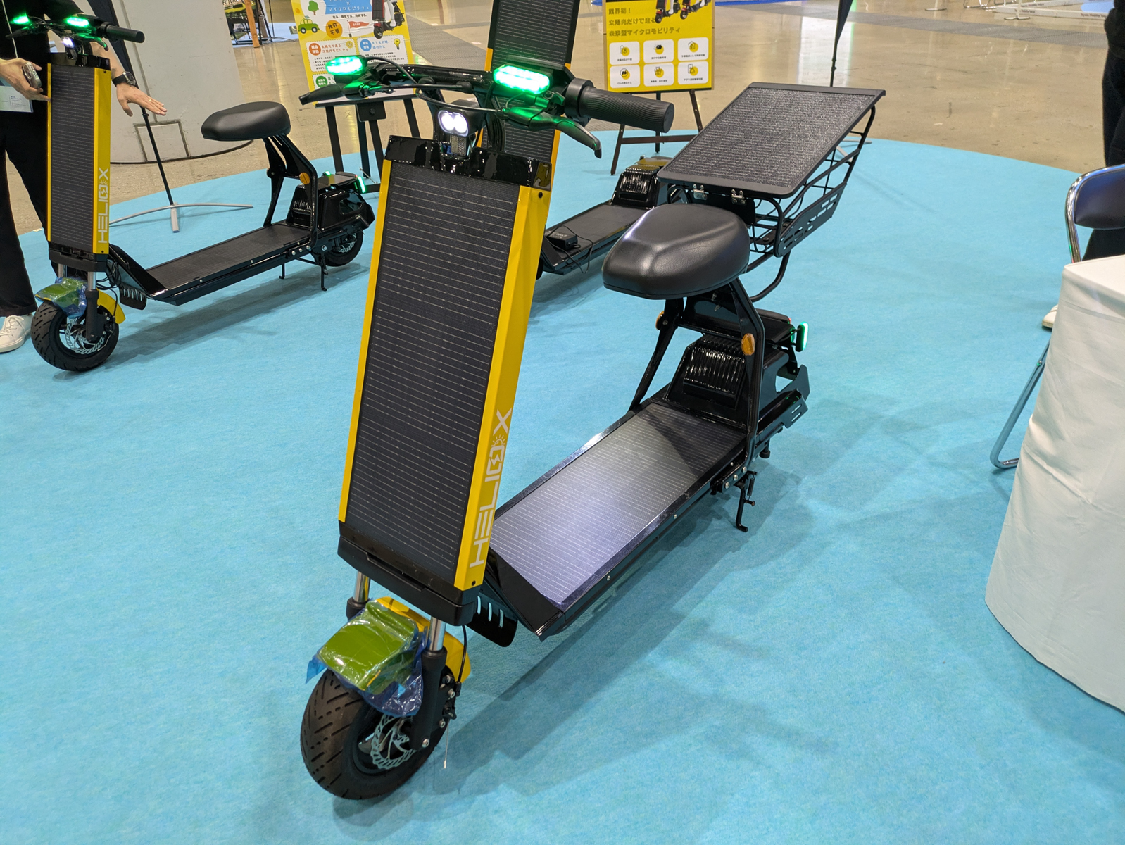 Helioxのブースでは、車体に搭載したソーラーパネルにより走行中や駐車中にも太陽光から補電できる、免許不要の特定小型モビリティ「座り乗り型ソーラースクーター」「立ち乗り型ソーラーキックボード」を展示。価格は約26万円。試乗もできる