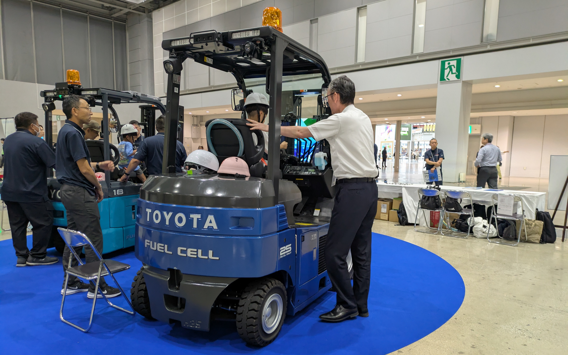 トヨタL＆Fは、水素を燃料として動き、稼働中にCO2を一切排出しないエコフォークリフト「燃料電池フォークリフト」2台を展示。実際に運転席に載って記念撮影もできる