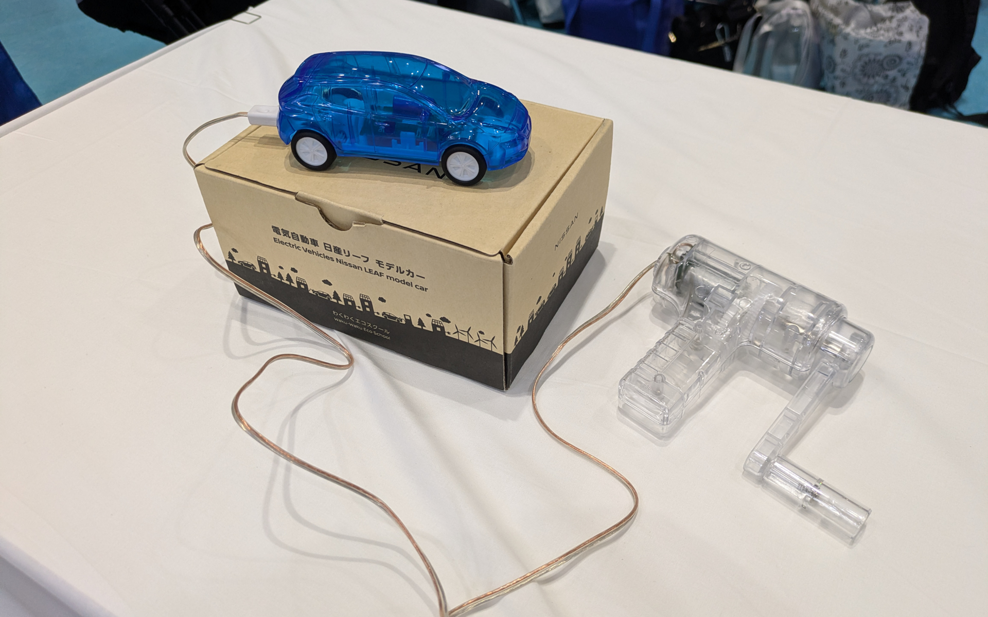 日産でんきは、自分でローラーを回して旧型「リーフ」の模型に内蔵されている蓄電池を充電し、特設コースを走らせるワークショップも展開している