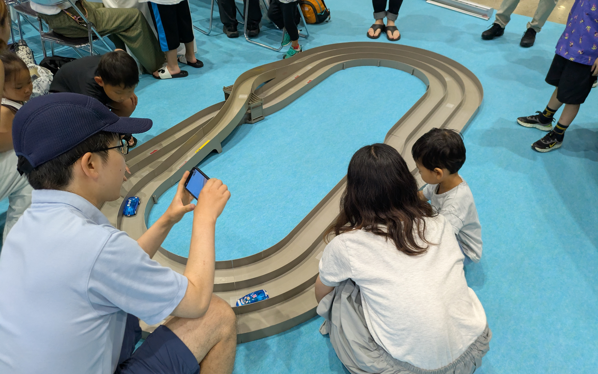 日産でんきは、自分でローラーを回して旧型「リーフ」の模型に内蔵されている蓄電池を充電し、特設コースを走らせるワークショップも展開している