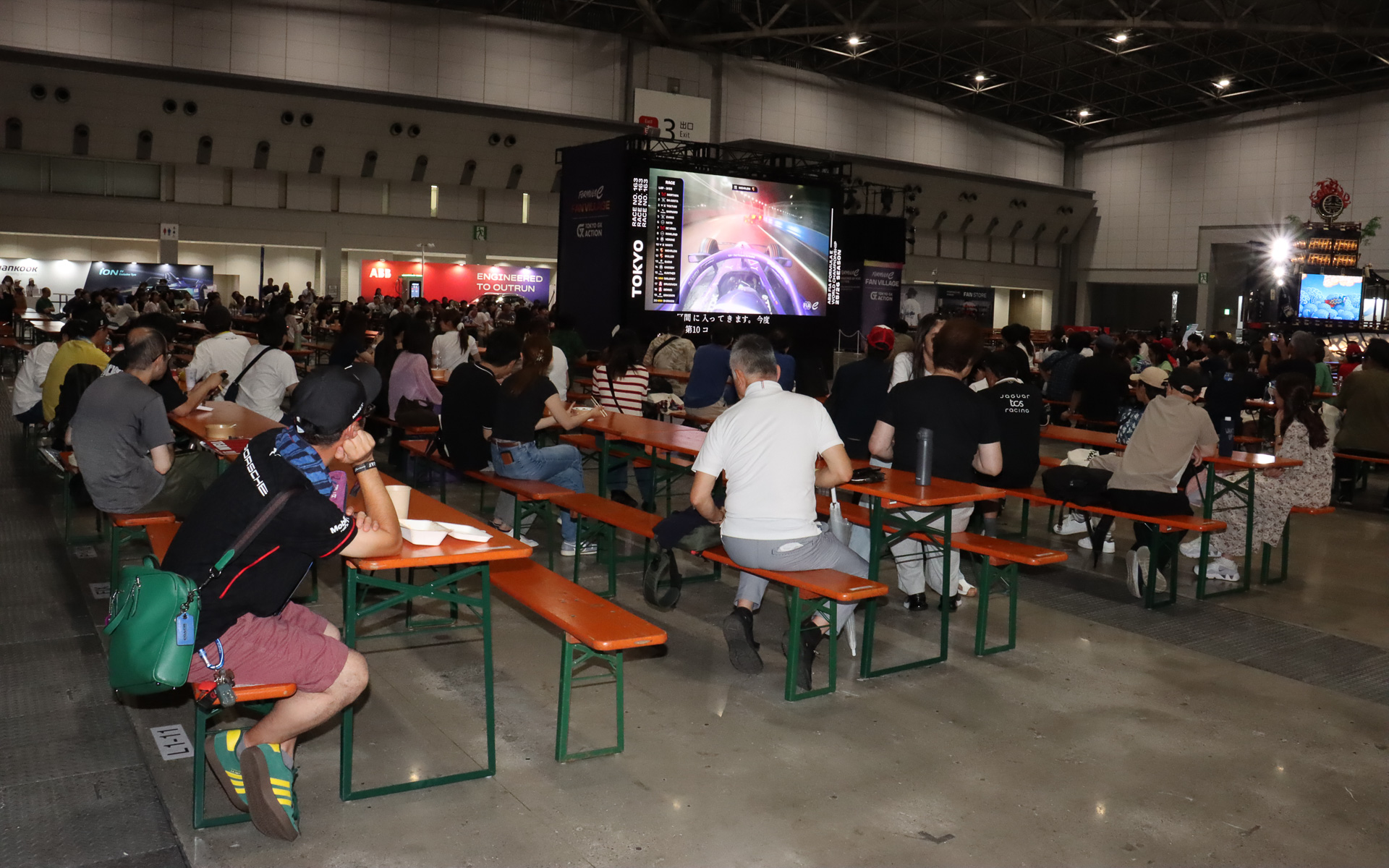 ライブビューイングは場内3か所にある大型ディスプレイで行なわれ、空調の効いた屋内でモータースポーツアナウンサーのピエール北川氏の実況＆解説を聞きながらレースを楽しんでいた