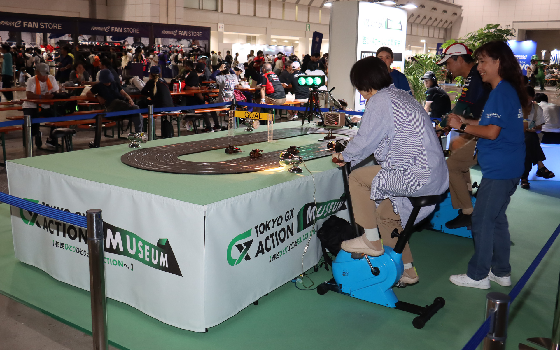 エアロバイクのペダルを漕いで発電した電気でミニチュアフォーミュラEマシンを走らせるレースゲーム