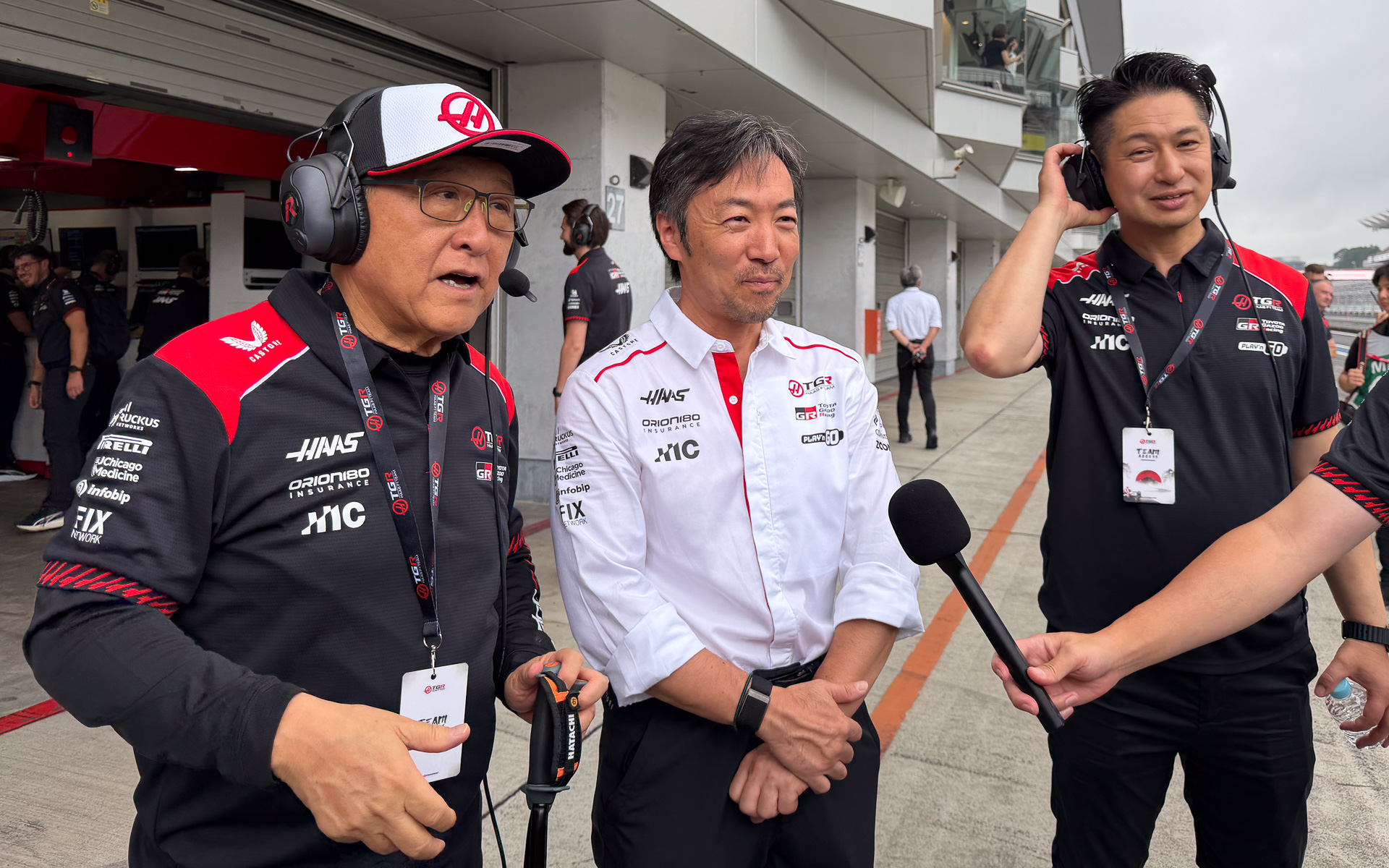 ハースF1のTPCを訪れた小松礼雄ハースF1チーム代表（中央）、トヨタ自動車株式会社 代表取締役会長 豊田章男氏（左）、同 モータースポーツ部 加地雅哉部長（右）