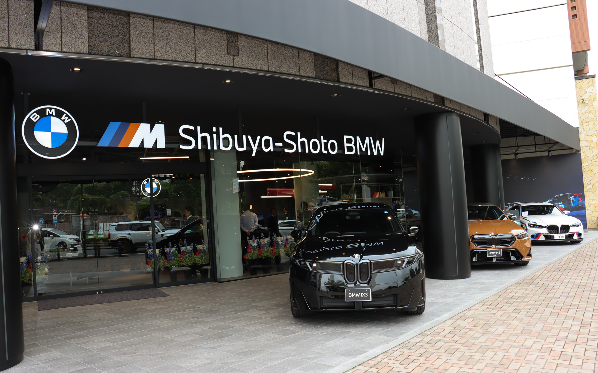 「渋谷松濤 BMW」の正面入口と屋外展示スペース。BMW Motorsport認定店であることをアピールするため、世界限定50台で日本には1台のみが入荷した「BMW 3.0 CSL」も特別展示された