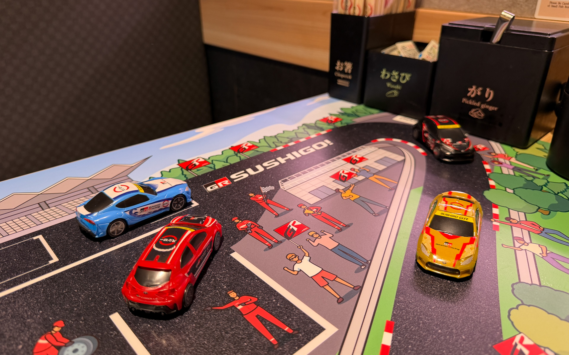 実店舗でのおすしが流れるレーンでの遊びは厳禁だが、テーブルではミニカー遊びもできる