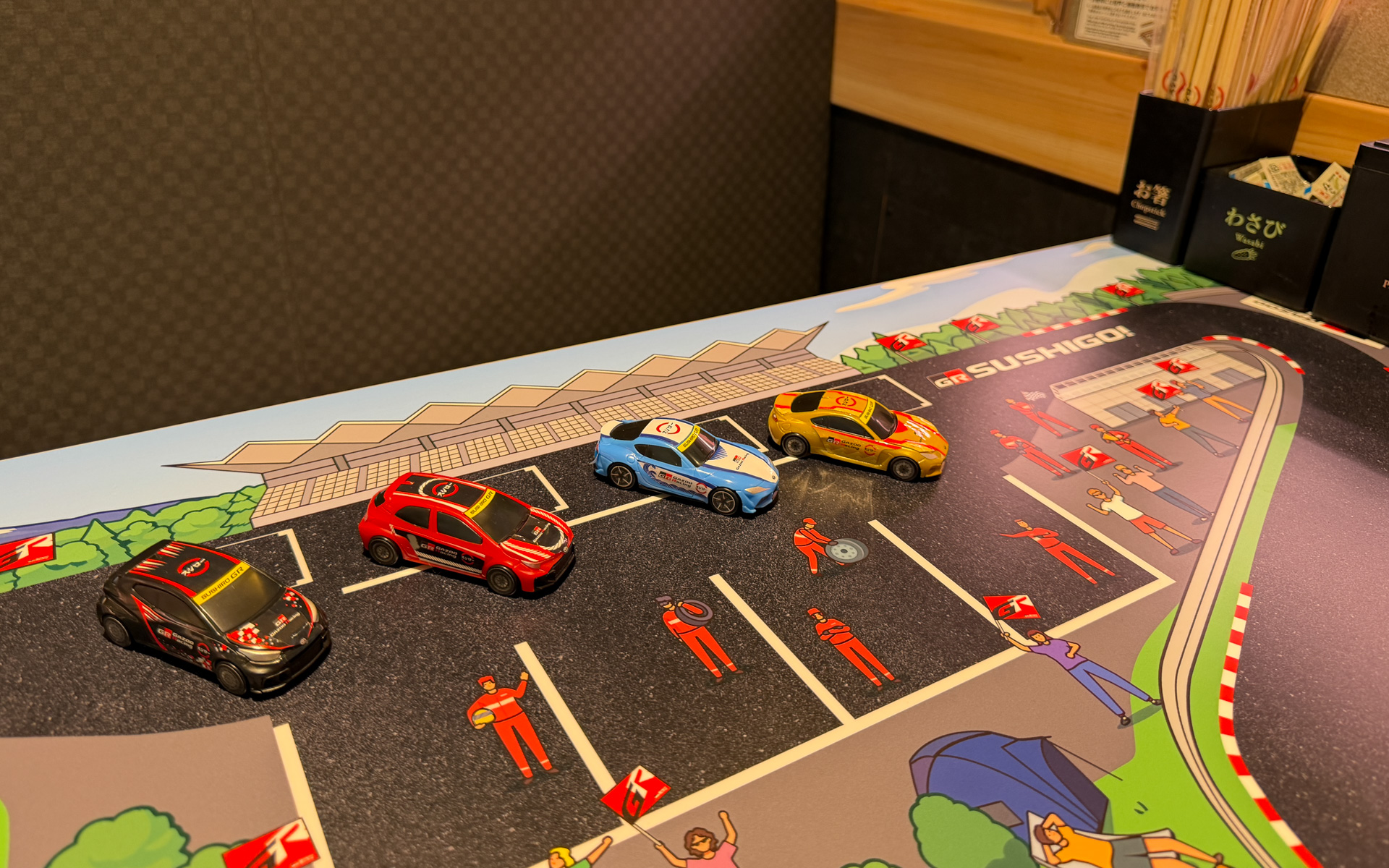 実店舗でのおすしが流れるレーンでの遊びは厳禁だが、テーブルではミニカー遊びもできる