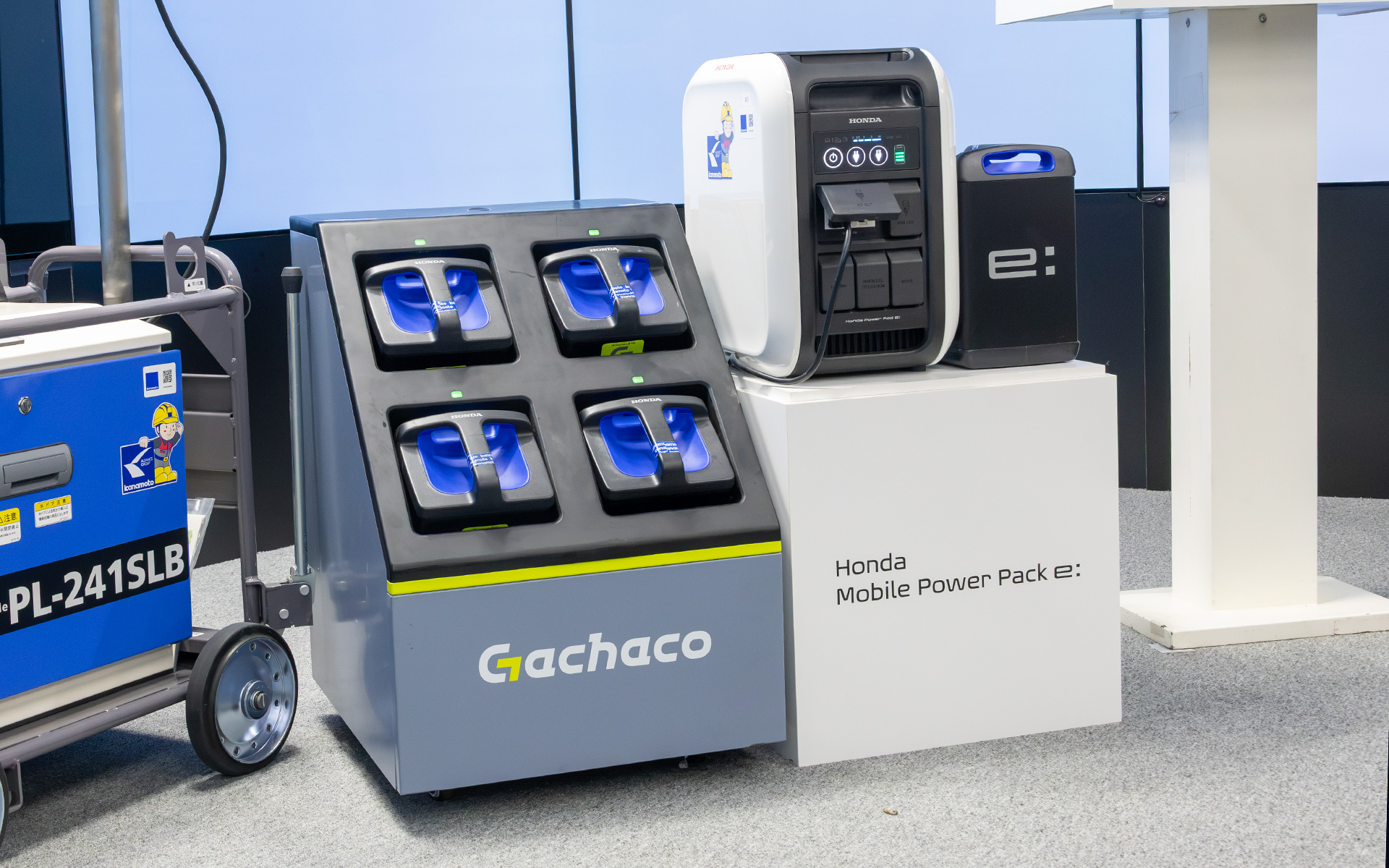 左側にあるのは電動バイク向けバッテリシェアリングサービス「Gachaco（ガチャコ）」のバッテリステーション。電池が減ったモバイルパワーパック イーを充電済みのものに交換できる。今回の実証事業ではこのバッテリステーションが使用される