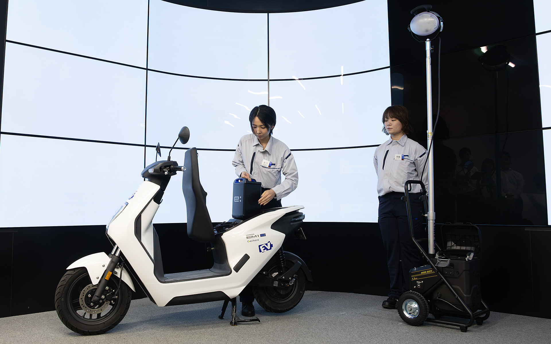 EVバイクからモバイルパワーパック イーを取り出して、投光器へ移し替えるデモンストレーションも行なわれた
