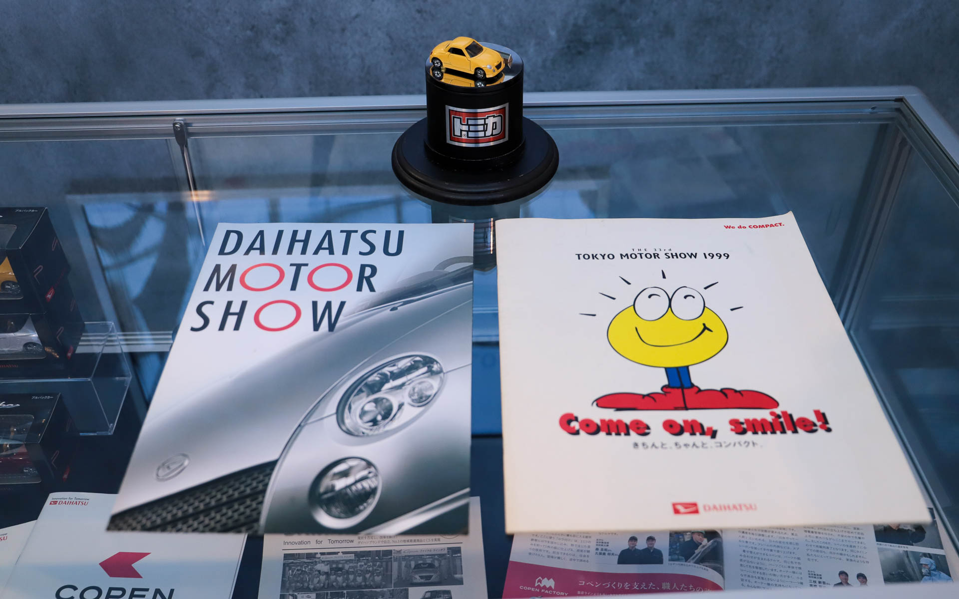 コペンファクトリーで使われていたつなぎなどのほか、これまでに登場したコペンのミニカーやオリジナルグッズ、パンフレットなどの貴重なアイテムも展示されている
