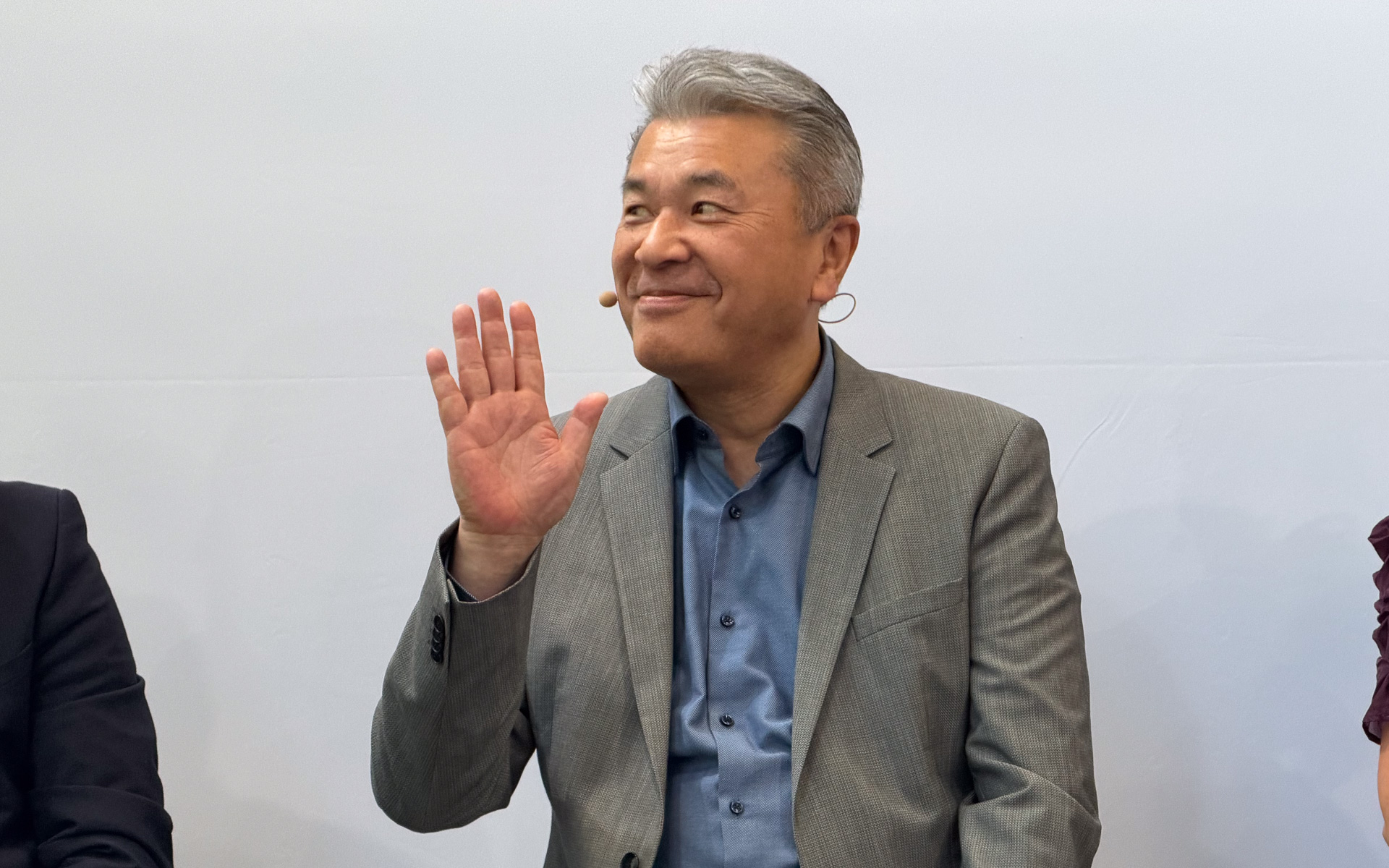 欧州での投資家説明会後に開催された「IAA TRANSPORTATION 2026 in Hannover」で会見に望む中嶋裕樹副社長。スカニアとの共同会見前に欧州メディアに手を振る