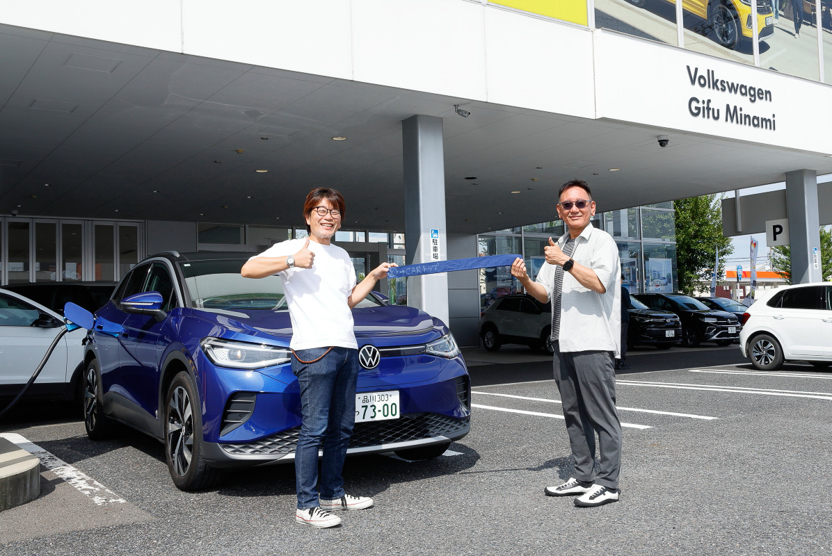 「Volkswagen岐阜南」でCARトップから取材に来ていたモータージャーナリストの山田弘樹氏（左）からタスキを受け試乗スタート！