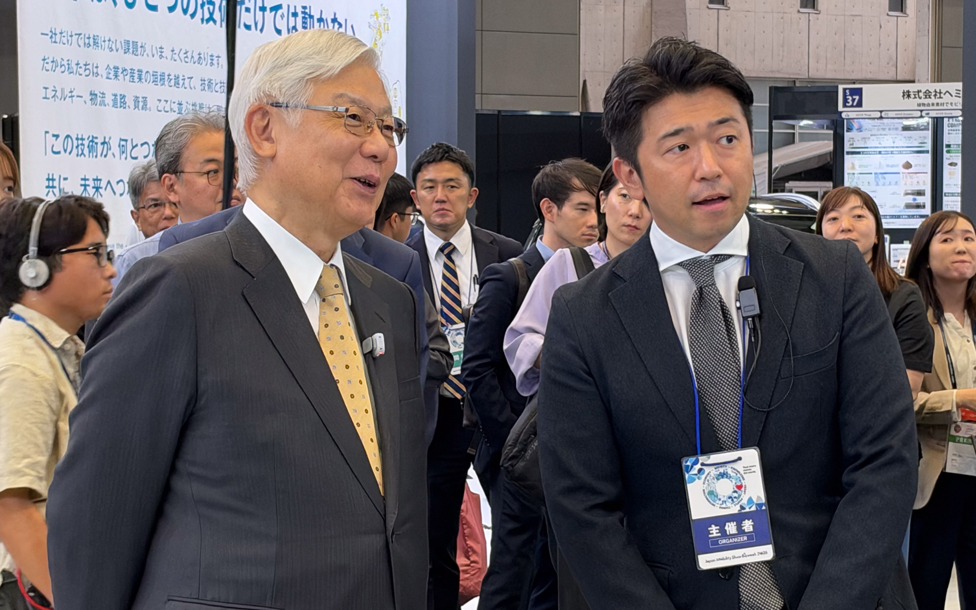 新野会長（左）に展示説明を行なう自工会 モビリティショー委員会 ショー企画部会 部会長 齋藤隆幸氏（右）