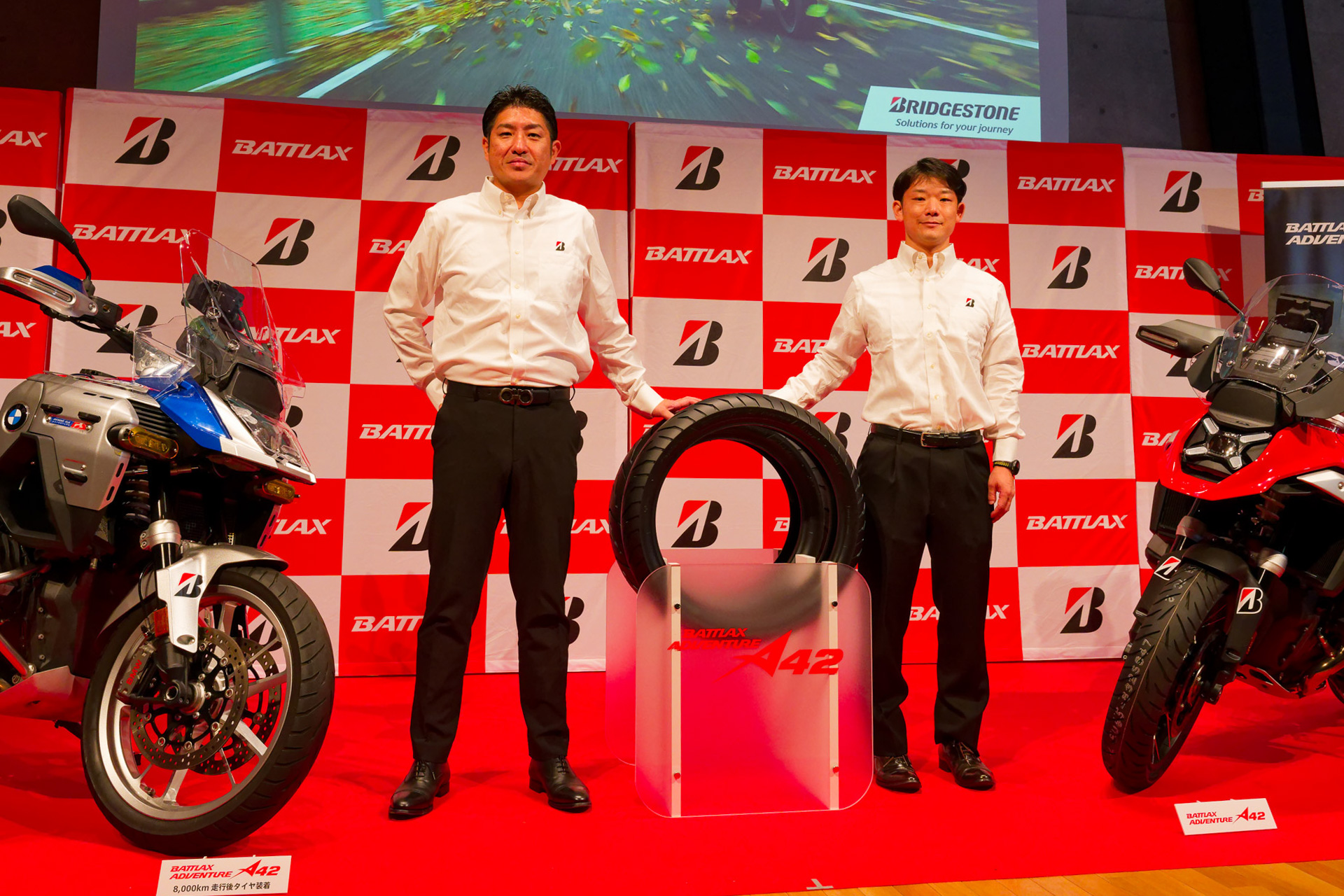 ブリヂストンのアドベンチャーモデル向け二輪タイヤ新商品「BATTLAX ADVENTURE A42」発表会。写真左から株式会社ブリヂストン グローバルMCタイヤ事業部長 坂上賢崇氏、同MCタイヤ開発部 MCタイヤ設計第2課 四宮一輝氏