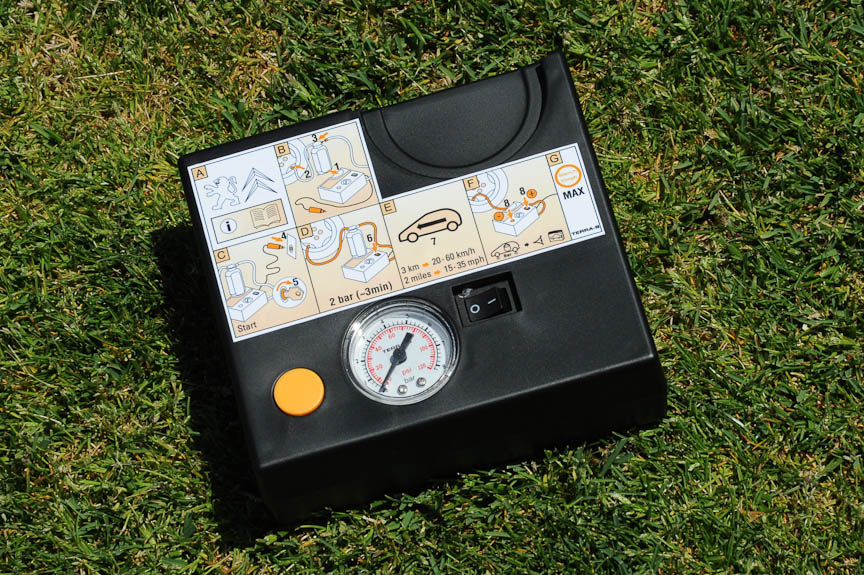 スペアタイヤはなく、パンク修理キットが搭載される。写真右は修理キットに含まれる電動エアコンプレッサー