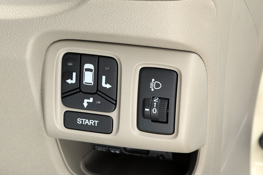 ステアリングコラム右側に用意されるパネルは、手動式のヘッドライトのレベリング機能と、スマートパーキングアシストシステムの操作部。スマートパーキングアシストシステムの作動は下の動画を参照いただきたいが、右バック駐車の場合、バックする方向のスイッチ（写真左）を押してから、駐車したい枠の手前の白線に右ドアのインジケーター（写真右）をあわせて停車し、スタートボタン（写真左）を押せば、あとは周囲に注意しながら、音声の指示に従ってアクセルとブレーキ、シフトレバーを操作すればよい