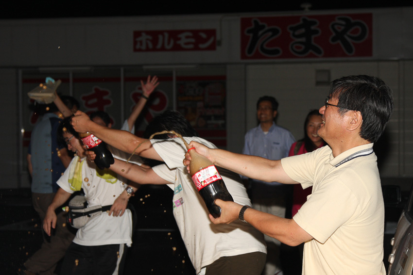 チャレンジ続行中のため、シャンパンではなく“コカコーラ・ファイト”で記録更新を祝う参加ドライバーたち