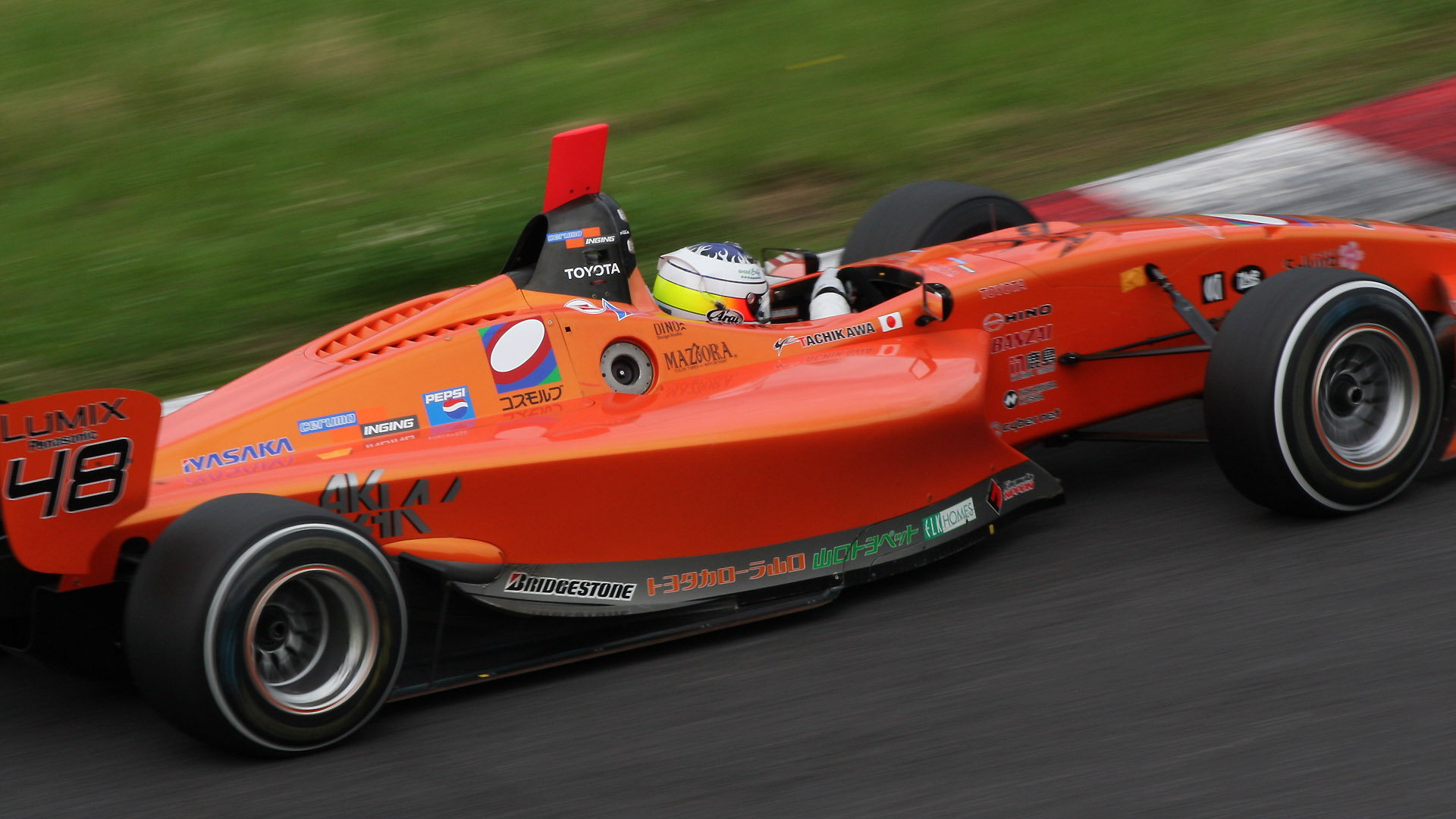 200mm（320mm相当） 1/125秒 F16。コーナーアウト側から撮るとマシンの前後がブレやすい（クリックすると1920×1080ピクセルの画像が開きます）