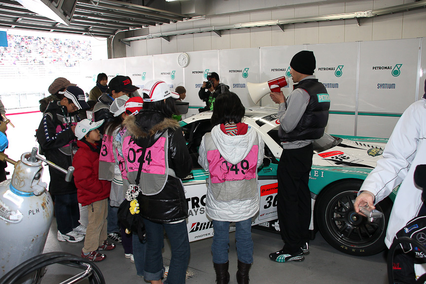 「モータースポーツお仕事体験コーナー」の「キッズ記者体験」の様子。PETRONAS TOM'Sのピットで熱心に取材を行っていた