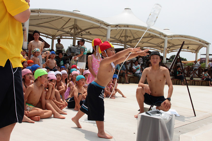 おぼれている人が捕まるために、水入りのペットボトルを投げ入れる