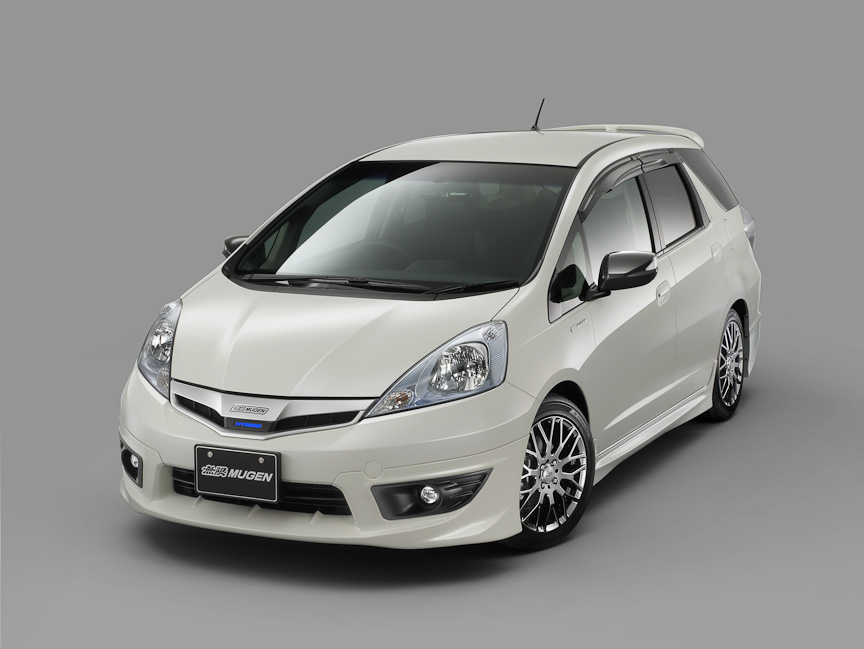 無限製エアロを装着したフィット シャトル（ハイブリッド）。標準装備されるフォグライトとの同時装着も選べるフロントアンダースポイラー、サイドスポイラー、リアアンダースポイラーの3点セット（それぞれ単体での購入も可能）。ハイブリッド車専用エアロではロゴが光る「ハイブリッドイルミネーショングリル」を設定。塗装済み15万6450円、非塗装13万5450円