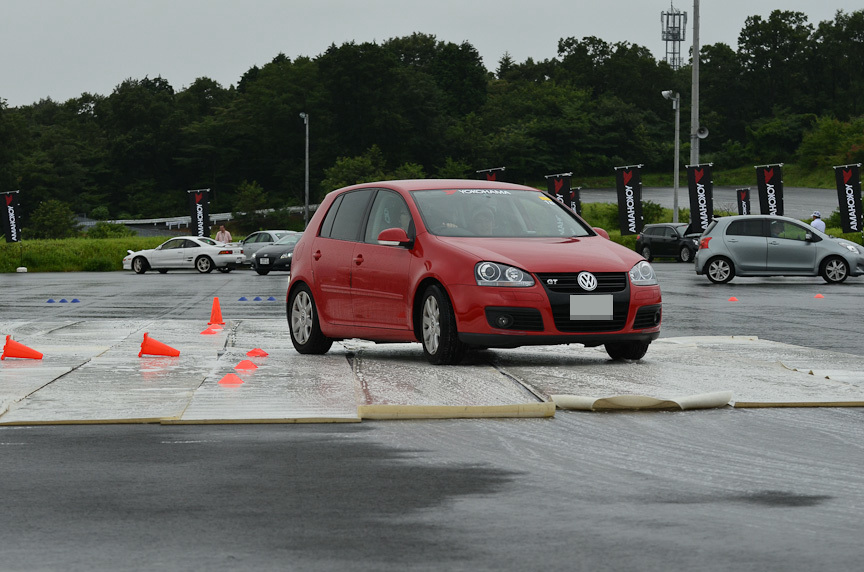 第3レーンはシートの上に洗剤入りの水を撒いた低μ路。写真中央のロードスターは後輪がスリップしているのが分かる