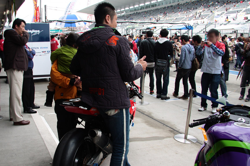 ピットウォークで写真撮影やサインをする出口選手