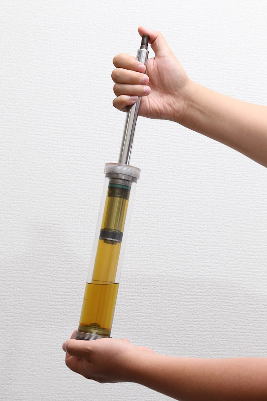 複筒式ダンパーを圧縮していったときの様子。ピストンロッドを押し込むと、副室の油面が上がり、ガス室が圧縮されているのが分かる